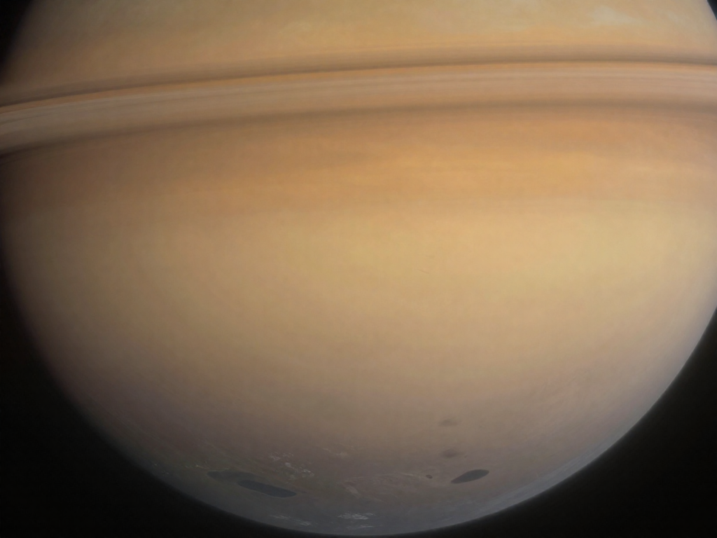 Titan's hazy orange atmosphere above dark methane lakes